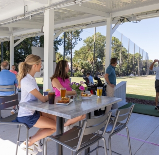 group of people at a driving range