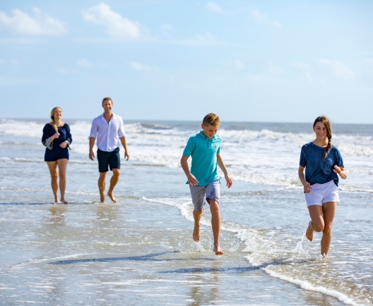 family splashing in the water on the beach