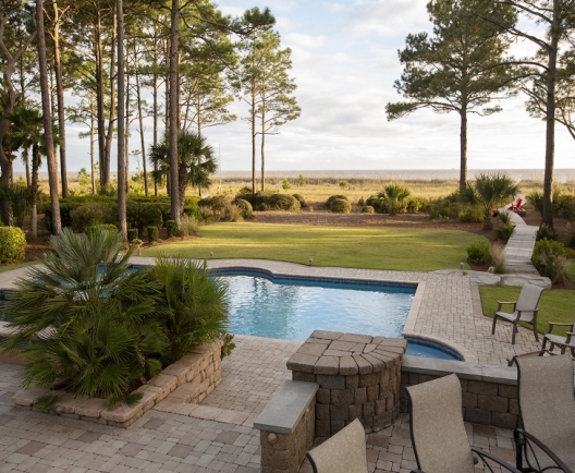 vacation home back yard with in ground pool and pathway leading to the beach