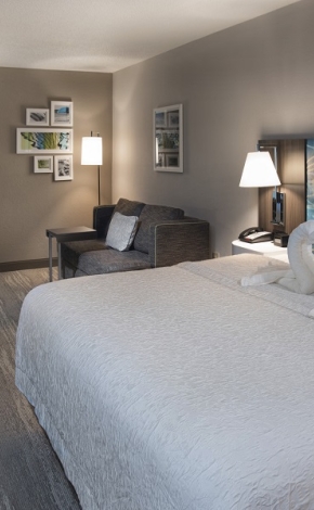 hotel room with large bed and white sheets