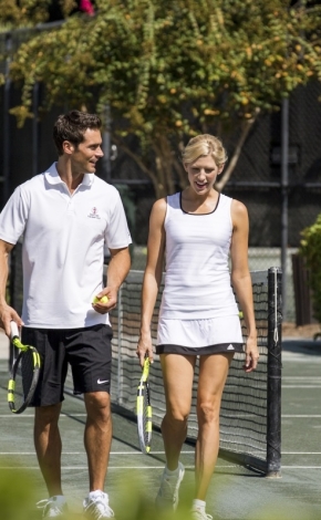 Two people walking on the tennis court