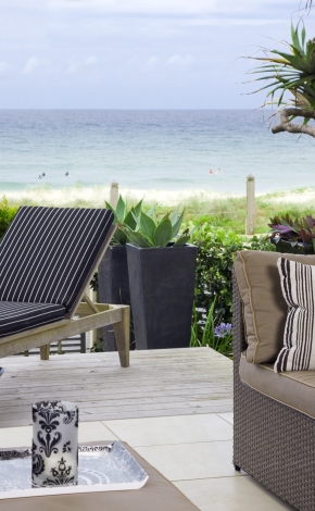 patio looking out at the beach with patio furniture