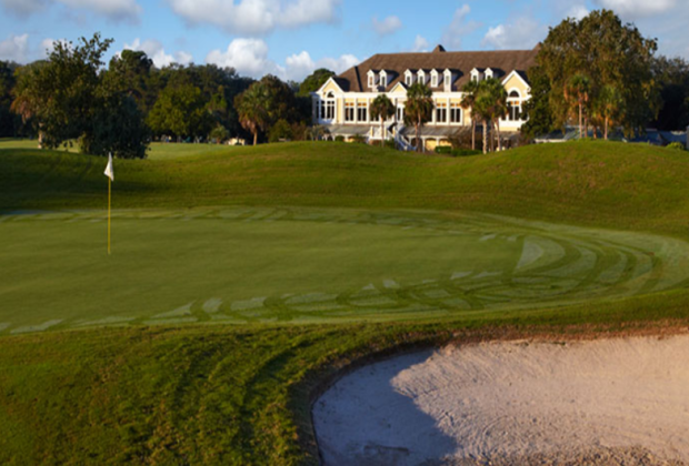 Golf course green with clubhouse in the distance