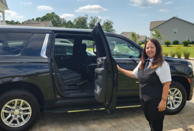 Palmette car service chauffeur holds vehicle door open