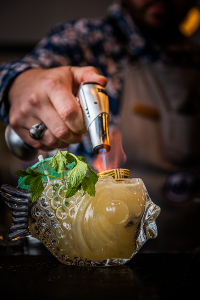 Bartender making a fancy cocktail in a fish glass
